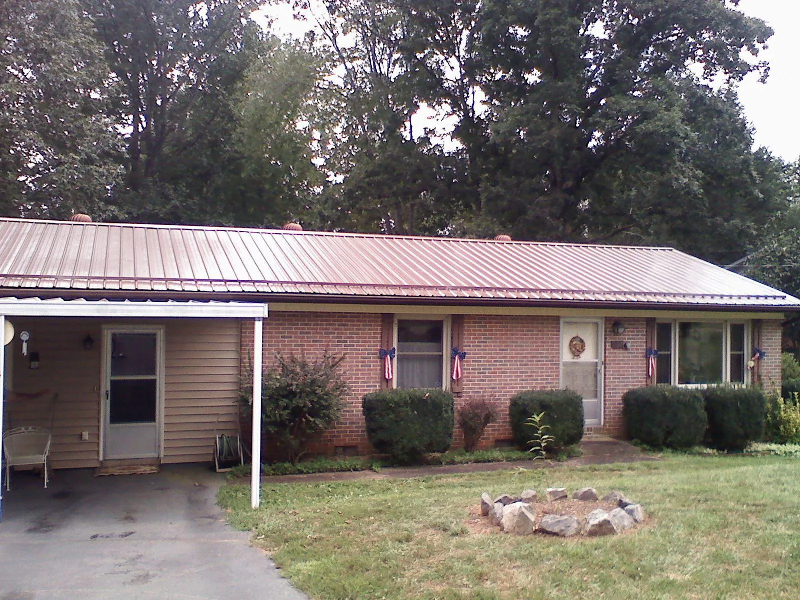 Bronze metal roof and carport on a brick ranch home — Roof Repair work by our crew in Sherman